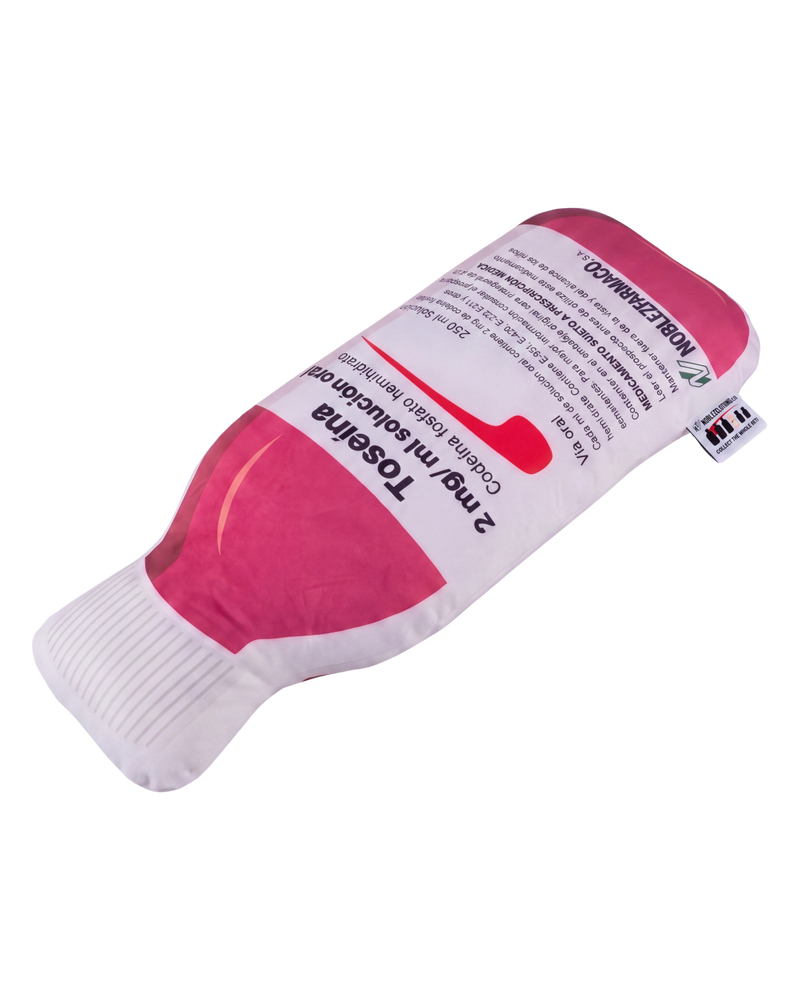Toseina Pillow lying at an angle - plush medicine bottle cushion showing depth and woven hang tag